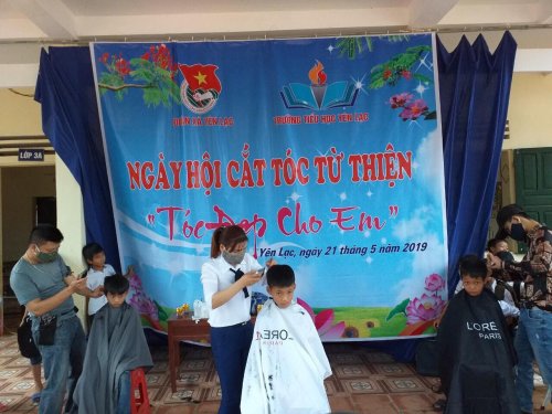 Các tình nguyện viên tiến hành tạo mẫu tóc cho các em học sinh.jpg